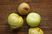 Tomatillos mit und ohne Hülle auf Holzuntergrund