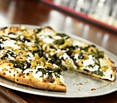 Griechische Pizza mit Feta und Oliven, angeschnitten