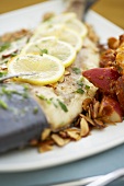 Pompano mit Mandeln, Zitronenscheiben & roten Bratkartoffeln