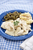 Chicken and Dumplings Over Mashed Potatoes with Beans on a Blue Plate