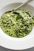Creamed Spinach in a White Bowl with a Spoon