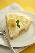 Slice of Banana Cream Pie on a White Plate with a Fork