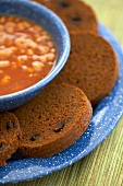 Slices of Boston Brown Bread with a Bowl of Baked Beans; Close Up