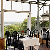 Tische in Restaurant am Fenster mit Ausblick über Landschaft