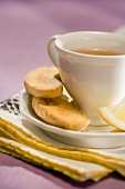 Cup of Tea on a Saucer with Biscotti and Lemon Wedge