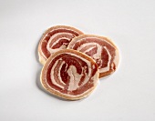 Three Slices of Pancetta on a White Background