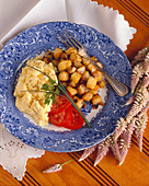 Hash Brown Potatoes and Scrambled Eggs on a Plate with Tomato