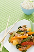 Sweet and Sour Pork with Vegetables on a Square Plate with Chopsticks