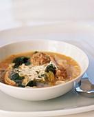 Bowl of Meatball Soup with Pasta, Chicken and Greens