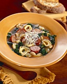 Suppe mit Tortellini, Wurstscheiben und Gemüse