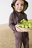 Little Girl Holding a Basket of Grapes