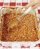 Baked Beans aus einer Aluschale löffeln