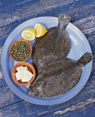 Fresh Flounder on Plate with Butter, Lemons and Capers