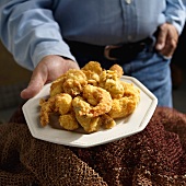 Man Holding a Plate of Fried Cornmeal Battered Shrimp and Oysters