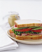 Sandwich mit Schinken, Tomate, Salatblatt und Avocado