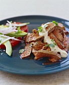 Sliced Steak with Sauce and Avocado and Tomato Salad