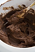 Chocolate Icing in a Mixing Bowl with a Wooden Spoon