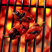 Three Red Jalapeno Peppers on Hot Grill