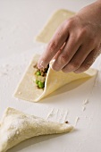 Child Folding Meat Filled Pastry Triangles