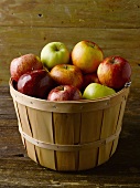 Verschiedene Apfelsorten in einem Holzkorb