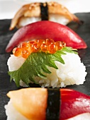 Verschiedene Nigiri-Sushi auf einer Steinplatte
