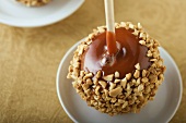 Toffee apple coated with chopped nuts
