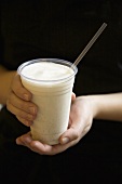 Hands Holding Cardamom Lassi with Straw