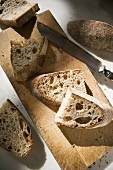 Sliced Crusty Bread on Cutting Board; Knife