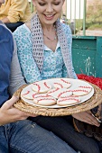 Man Offering Woman Plate of Baseball Cookies