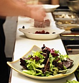 Chef Preparing a Salad of Mixed Baby Greens