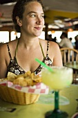 Frau mit Chips und Margarita im Restaurant