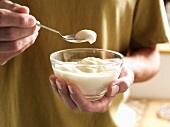 A Man Taking a Spoonful of Vanilla Pudding