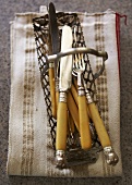 Antique Silverware in Wire Basket on Folded Napkin