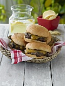 Cheeseburgers in a Basket on Picnic Table with Lemonade