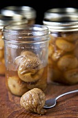 Fork Piercing a Canned Fig; Canned Figs in Jars