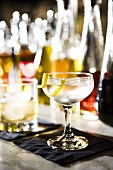 Martini vor vielen Spirituosenflaschen in einer Bar