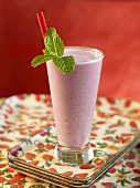 Strawberry Smoothie with Straw and Mint Garnish