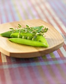 Open Sugar Snap Pea with Thyme on a Cutting Board
