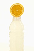 Halbe Zitrone auf Plastikflasche mit Fitnessdrink