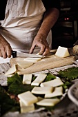 Man Slicing Cheese on Cutting Board