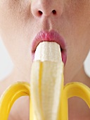 Frau lutscht an einer geschälten Banane