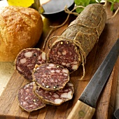 Sliced Tuscan Salami on Cutting Board with Knife; Bread