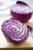 Fresh red cabbage, halved, on chopping board