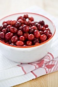 Fresh cranberries in bowl on tea towel