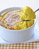Corn Spoon Bread Being Spooned Out of Baking Dish