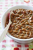 Drunken Beans; Beer Baked Beans in Serving Dish with Spoon
