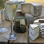 Glasses of White Wine with Assorted Cheese on Wooden Table