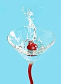 An olive falling into a vodka Martini