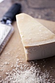A Wedge of Parmesan Cheese; Grated Parmesan Cheese; Grater