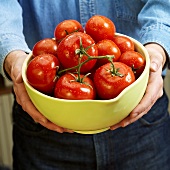 Man holding a bowl of fresh tomatoes